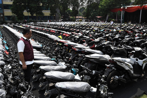 Tim penyidik Dittipidum Bareskrim Polri mengamati barang bukti motor yang disita dari kasus tindak pidana penipuan dan atau penadahan kendaraan bermotor jaringan internasional di Lapangan Slog Polri, Jakarta Timur, Kamis (18/7/2024). Foto: Fakhri Hermansyah/ANTARA FOTO