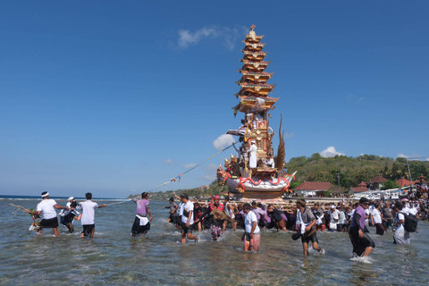 Sejumlah umat Hindu mengarak bade atau menara bertingkat tujuh saat melintasi pantai pada upacara ngaben massal di Desa Adat Karangsari, Nusa Penida, Klungkung, Bali, Kamis (18/7/2024). Foto: Nyoman Hendra Wibowo/ANTARA FOTO