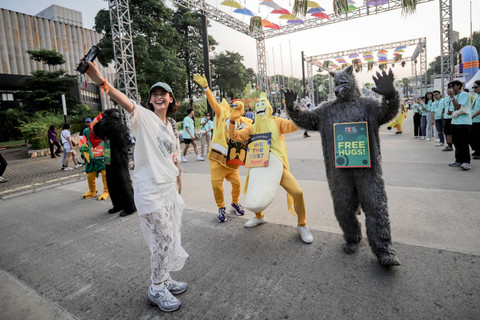 Pengunjung berswafoto dengan maskot We The Fest 2024 di kompleks Stadion Gelora Bung Karno, Jakarta, Jumat (19/7/2024). Foto: Jamal Ramadhan/kumparan