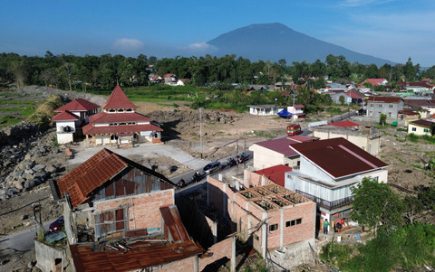 Foto udara warga membangun kembali rumahnya yang hancur akibat terdampak banjir lahar dingin Gunung Marapi di Simpang Bukik, Nagari Bukik Batabuah, Agam, Sumatera Barat, Sabtu (20/7/2024). Foto: Iggoy el Fitra/Antara Foto