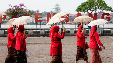 Aksi Ibu-ibu dari sejumlah organisasi yang mengikuti parade dalam rangka menyambut hari kebaya nasional yang digelar di pelataran Benteng Kuto Besak Palembang, Minggu (21/7) Foto: ary priyanto/urban id