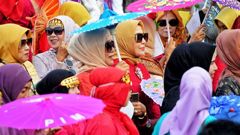 Sejumlah peserta parade kebaya yang kompak mengenakan aksesoris berupa kacamata dan payung saat mengikuti kegiatan parade di pelataran Benteng Kuto Besak Palembang, Minggu (21/7) Foto: ary priyanto/urban id