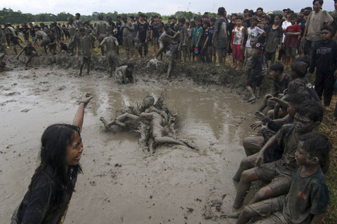 Warga bermain lumpur pada ritual adat Kebo-keboan Alas Malang, Banyuwangi, Jawa Timur, Minggu (21/7/2024) Foto: Budi Chandra Setya/ANTARA FOTO