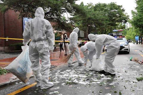 Petugas Korea Selatan membersihkan isi balon pembawa sampah yang dikirim oleh Korea Utara setelah mendarat di sebuah jalan di Seoul pada 24 Juli 2024. Foto: Yonhap/AFP