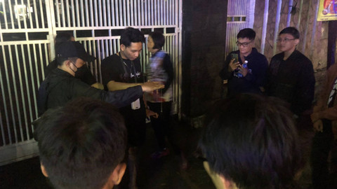 Perserta tur Bandros Braga Mystery saat mencoba berinteraksi dengan sosok astral lewat medium pendulum di depan salah satu SMA Negeri di Bandung, Kamis (25/7/2024). Foto: Robby Bouceu/kumparan