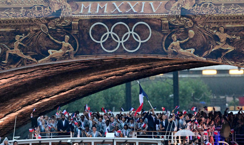 Sejumlah atlet Prancis mengikuti defile dengan menaiki kapal menyusuri sungai Seine saat pembukaan Olimpiade Paris 2024 di Paris, Prancis, Kamis (26/7/2024). Foto: Angelika Warmuth/REUTERS 