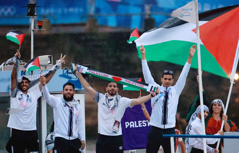 Kontingen Palestina mengikuti defile dengan menaiki kapal menyusuri sungai Seine saat pembukaan Olimpiade Paris 2024 di Paris, Prancis, Kamis (26/7/2024). Foto: Eloisa Lopez/REUTERS