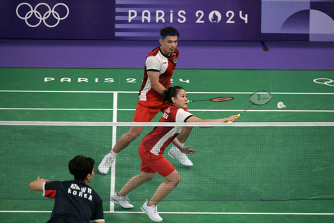 Pitha Haningtyas Mentari dari Indonesia melakukan pukulan di samping Rinov Rivaldy dalam pertandingan penyisihan grup bulu tangkis ganda campuran melawan Korea Selatan dalam Olimpiade Paris 2024 di Porte de la Chapelle Arena, Paris, 27 Juli 2024. Foto: Arun Sakar/AFP