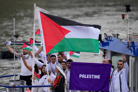 Kontingen Palestina mengikuti defile dengan menaiki kapal menyusuri sungai Seine saat pembukaan Olimpiade Paris 2024 di Paris, Prancis, Kamis (26/7/2024). Foto: Kirsty Wigglesworth/AP Photo