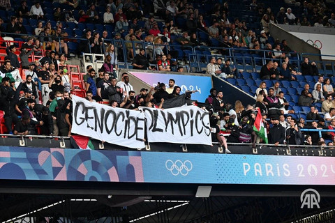 Sejumlah penonton saat pertandingan Israel vs Paraguay membentangkan banner "Genocide Olympics", di stadion Parc des Princes Foto:  Anadolu Agency 