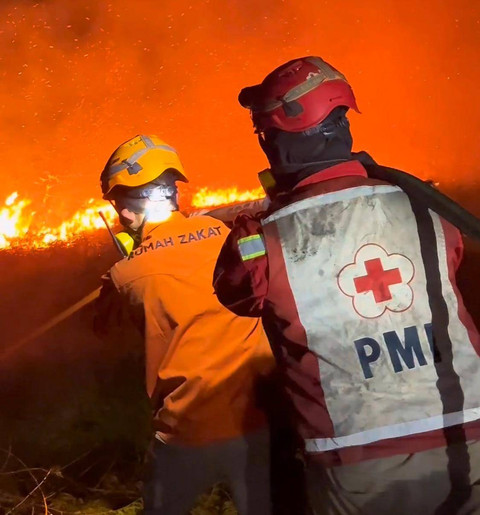 Tim pemadam dari Rumah Zakat dan PMI Kalbar saat memadamkan api di wilayah sekunder C Rasau Jaya. Foto: Dok. Rumah Zakat Kalbar 