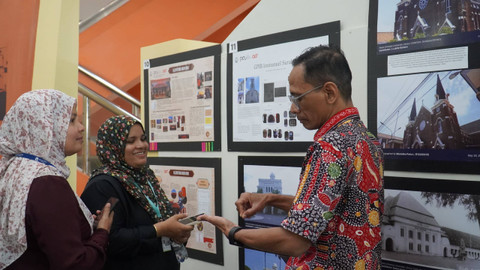 Dua perwakilan Maldives National University saling berdiskusi tentang fasilitas-fasilitas di perpustakaan.