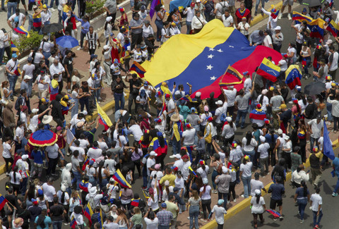 Orang-orang membawa bendera nasional Venezuela untuk memprotes hasil pemilu yang memberikan masa jabatan ketiga bagi Presiden Venezuela Nicolas Maduro, di Maracaibo, Venezuela, Rabu (31/7/2024). Foto: Isaac Urrutia/REUTERS