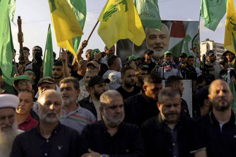Para demonstran memegang bendera dan senjata di samping foto mendiang pemimpin Hamas Ismail Haniyeh saat melakukan aksi protes untuk mengutuk pembunuhannya di Iran, di Sidon, Lebanon, Rabu (31/7/2024). Foto: Alkis Konstantinidis/REUTERS 