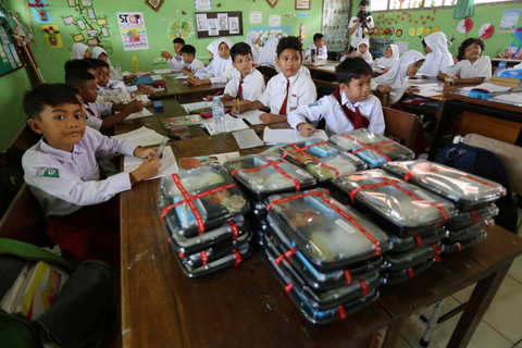 Sejumlah murid SD Negeri Klampis Ngasem 3 menunggu pembagian paket makanan saat uji coba pelaksanaan program makan bergizi gratis di SD Negeri Klampis Ngasem 3, Surabaya, Jawa Timur, Kamis (1/8/2024). Foto: Moch Asim/ANTARA FOTO 
