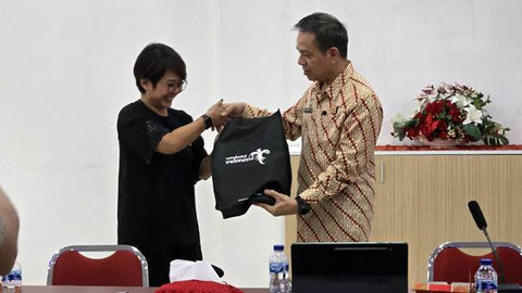 Kepala Kantor Imigrasi Kelas I TPI Manado, Rachmat, menerima cenderamata dari Direktur Kajian Strategis Kementerian Pariwisata dan Ekonomi Kreatif (), Agustini Rahayu.