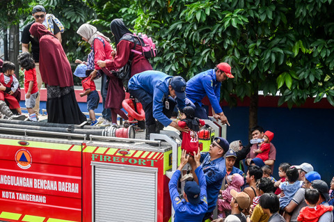 Petugas membantu anak-anak menaiki mobil pemadam kebakaran saat edukasi profesi pemadam kebakaran di UPT Pemadam Kebakaran Ciledug, Tangerang, Banten, Sabtu (3/8/2024). Foto: Rivan Awal Lingga/ANTARA FOTO