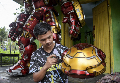Perajin menyemprotkan cat pada robot cosplay yang terbuat dari busa EVA, di sebuah bengkel di Ciamis, Jawa Barat, Sabtu (3/8/2024). Foto: TIMUR MATAHARI/AFP