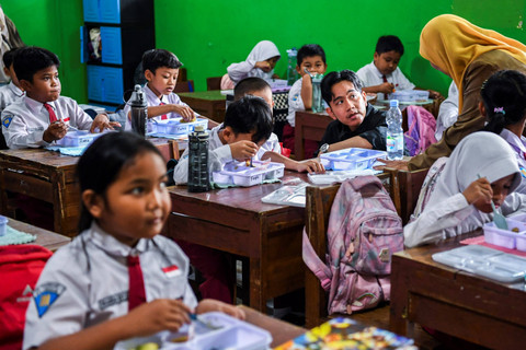 Wakil Presiden terpilih Gibran Rakabuming Raka berbincang dengan siswa saat meninjau uji coba pelaksanaan program makan bergizi gratis di SDN 4 Tangerang, Kota Tangerang, Banten, Senin (5/8/2024). Foto: Galih Pradipta/ANTARA FOTO