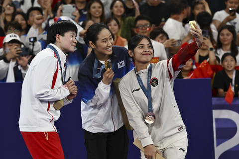 Dari kiri peraih medali perakHe Bingjiao dari Tiongkok, , An Se-young dari Korea Selatan emas dan Gregoria Mariska Tunjung dari Indonesia perunggu, berswafoto di atas podium tunggal putri bulu tangkis Olimpiade Paris 2024, Senin (5/8/2024). Foto: Dok. NOC Indonesia 