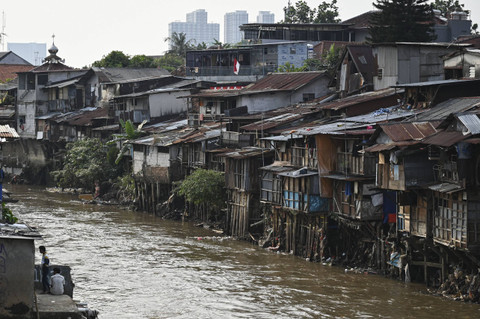 Dua warga bercengkrama di permukiman bantaran sungai di kawasan Manggarai, Jakarta, Senin (5/8/2024). Foto: Fauzan/ANTARA FOTO