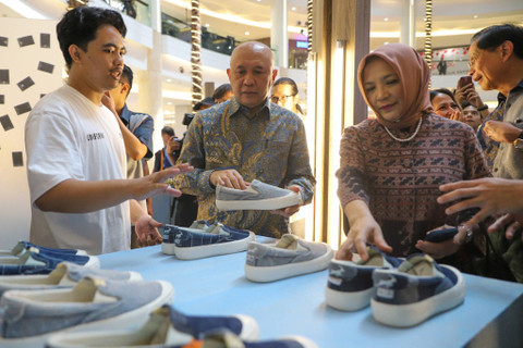 Menteri Koperasi dan UKM Teten Masduki melihat produk sepatu usai membuka acara BCA UMKM Fest 2024 di kawasan Kuningan, Jakarta, Rabu (7/8/2024). Foto: Iqbal Firdaus/kumparan