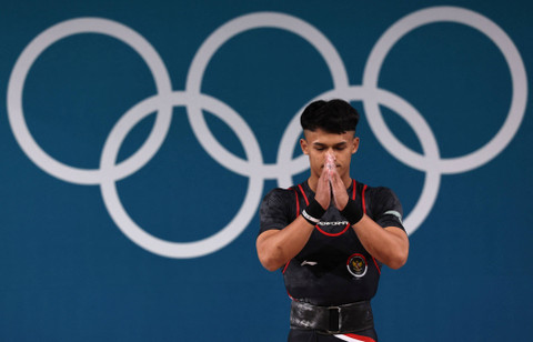 Rizki Juniansyah beraksi di cabor angkat besi Olimpiade Paris 2024. Foto: REUTERS/Amanda Perobelli