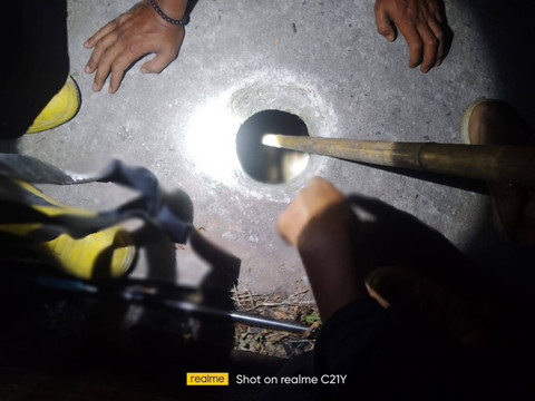 Petugas Damkar Kabupaten Lampung Selatan saat mengevakuasi handphone milik warga yang terjatuh di septi tank. | Foto: Dok Damkarmat Lampung Selatan