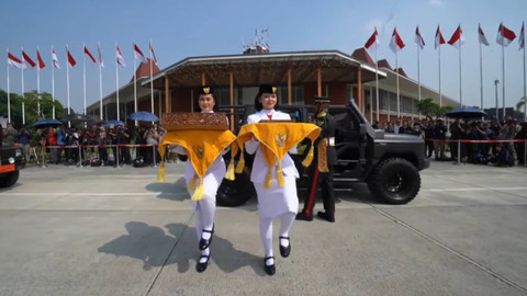 Tim Purna Paskibraka 2023 membawa duplikat bendera Merah Putih dan naskah teks proklamasi berjalan menuju kendaraan taktis maung dalam acara kirab bendera Merah Putih dan naskah teks proklamasi menuju Ibu Kota Nusantara di kawasan Monas, Jakarta. Foto: YouTube/Sekretariat Presiden