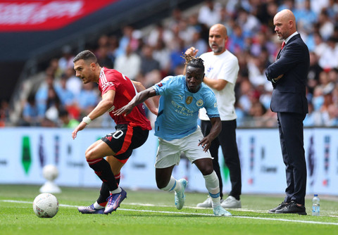 Diogo Dalot dari Manchester United berusaha menghalangi laju bola Jeremy Doku dari Manchester City di Stadion Wembley, London, Inggris, 10 Agustus 2024 Foto: REUTERS/Toby Melville