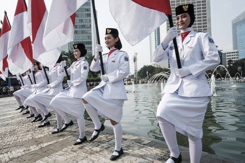 Sejumlah pasukan pengibar bendera (Paskibra) berbaris membawa bendera Merah Putih saat hari bebas kendaraan bermotor (HBKB) di Bundaran HI, Jakarta, Minggu (11/8/2024). Foto: Yasuyoshi Chiba/AFP