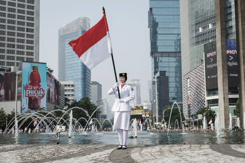 Sejumlah pasukan pengibar bendera (Paskibra) berbaris membawa bendera Merah Putih saat hari bebas kendaraan bermotor (HBKB) di Bundaran HI, Jakarta, Minggu (11/8/2024). Foto: Yasuyoshi Chiba/AFP