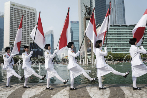 Sejumlah pasukan pengibar bendera (Paskibra) berbaris membawa bendera Merah Putih saat hari bebas kendaraan bermotor (HBKB) di Bundaran HI, Jakarta, Minggu (11/8/2024). Foto: Yasuyoshi Chiba/AFP