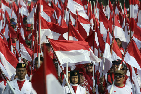 Sejumlah warga membawa bendera saat kirab bendera merah putih di Jalan Raya Tegar Beriman, Kabupaten Bogor, Jawa Barat, Minggu (11/8/2024). Foto: Yulius Satria Wijaya/ANTARA FOTO