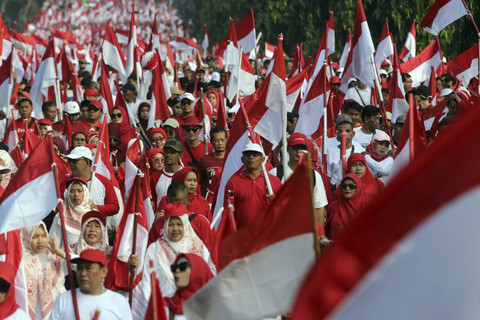 Sejumlah warga membawa bendera saat kirab bendera merah putih di Jalan Raya Tegar Beriman, Kabupaten Bogor, Jawa Barat, Minggu (11/8/2024). Foto: Yulius Satria Wijaya/ANTARA FOTO