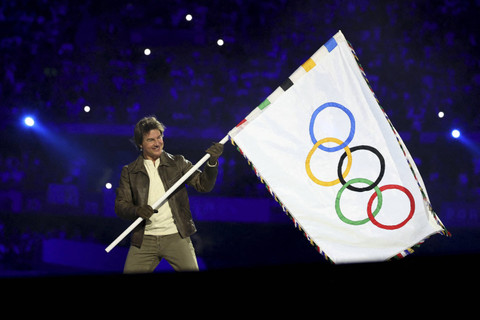 Aktor Tom Cruise memegang bendera Olimpiade selama upacara penutupan Olimpiade Paris 2024 di Stade de France, Saint-Denis, Prancis, Minggu (11/8/2024). Foto: PHIL NOBLE/REUTERS