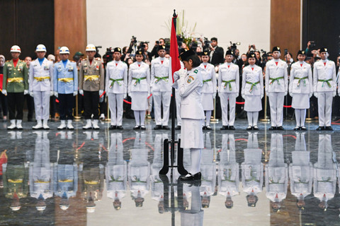 Anggota Paskibraka 2024 asal Sumatera Utara Violetha Agryka Sianturi mencium Bendera Merah-Putih dalam pengukuhan Paskibraka Tingkat Pusat 2024 di Istana Negara, Ibu Kota Nusantara (IKN), Kalimantan Timur, Selasa (13/8/2024). Tak boleh pakai jilbab. Foto: Sigid Kurniawan/ANTARA FOTO 