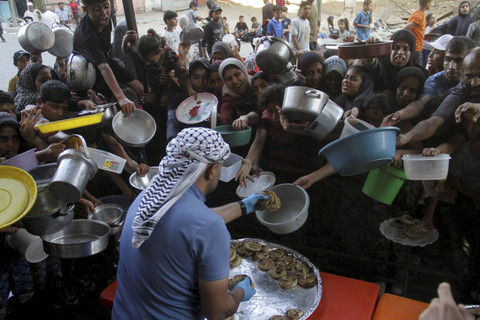 Seorang pekerja dapur umum membagikan makanan kepada warga Palestina, di tengah krisis kelaparan akibat konflik antara Israel dan Hamas yang terus berlanjut di Jalur Gaza utara, Kamis (15/8/2024). Foto: Mahmoud Issa/REUTERS