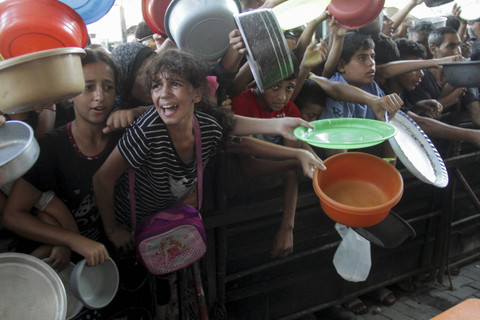 Warga Palestina bereaksi saat menunggu untuk menerima makanan yang dimasak oleh dapur umum, di tengah krisis kelaparan akibat konflik antara Israel dan Hamas yang terus berlanjut di Jalur Gaza utara, Kamis (15/8/2024). Foto: Mahmoud Issa/REUTERS