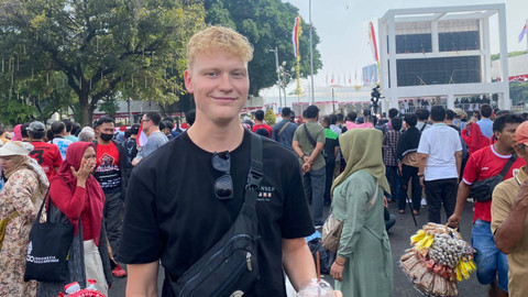Warga negara Belanda, Job (22), turut meramaikan perayaan HUT ke-79 RI di depan Istana Merdeka, Jakarta (17/8/2024). Foto: Abid Raihan/kumparan