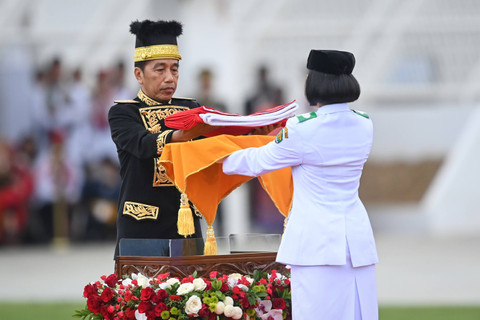 Presiden Joko Widodo  menyerahkan duplikat Bendera Pusaka kepada anggota Paskibraka 2024 Livenia Evelyn Kurniawan dalam upacara upacara HUT ke-79 RI Istana Negara IKN, Kalimantan Timur, Sabtu (17/8/2024). Foto: Hafidz Mubarak/ANTARA FOTO