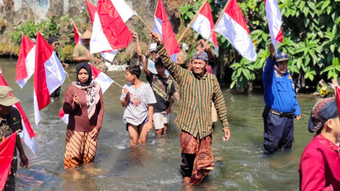 Warga mengibarkan 79 bendera merah putih di Kali Code, Sabtu (17/8/2024). Foto: Arfiansyah Panji/kumparan