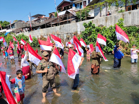 Warga mengibarkan 79 bendera merah putih di Kali Code, Sabtu (17/8/2024). Foto: Arfiansyah Panji/kumparan