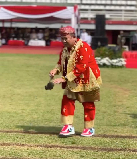 Bupati Jember, Hendy Siswanto (baju merah) mengambilkan sepatu anggota Paskibra yang terlepas. Foto: Mili.id