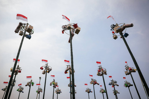 Peserta lomba panjat pinang berusaha mencapai puncak tiang untuk mengambil hadiah saat digelar lomba panjat pinang di Ancol, Jakarta, Sabtu (17/8/2024). Foto: Jamal Ramadhan/kumparan