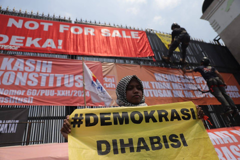 Demonstran memasang spanduk di depan gedung parlemen saat menuntut RUU Pilkada di Jakarta, Kamis (22/8). Foto: Jamal Ramadhan/kumparan