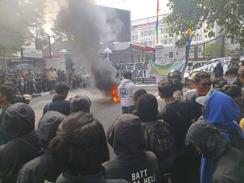 Massa Aksi demo revisi UU Pilkada di Bandung membakar spanduk di depan gedung DPRD Jawa Barat, Kamis (22/8/2024). Foto: Robby Bounceu/kumparan