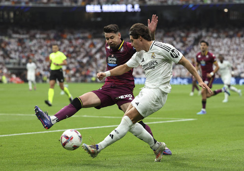 Pemain Real Madrid Fran Garcia beraksi dengan pemain Real Valladolid Luis Perez pada pertandingan La Liga antara Real Madrid melawan Real Valladolid di Santiago Bernabeu, Madrid, Spanyol, Minggu (24/8/2024). Foto: Violeta Santos Moura/REUTERS 