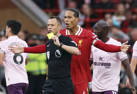 Pemain Liverpool Virgil van Dijk bereaksi saat Ryan Gravenberch diacungi kartu kuning oleh wasit Stuart Attwell pada pertandingan Liga Inggris antara Liverpool melawan Brentford di Stadion Anfield, Liverpool, Inggris, Minggu (25/8/2024). Foto: PHIL NOBLE/REUTERS