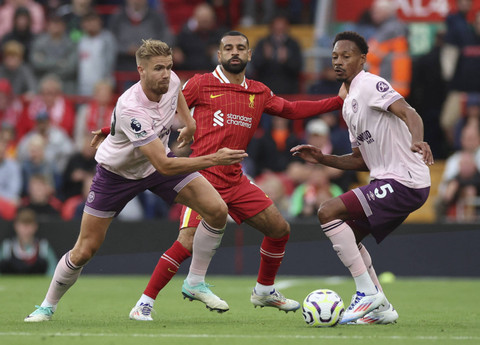 Mohamed Salah dari Liverpool beraksi dengan Kristoffer Ajer dan Ethan Pinnock dari Brentford pada pertandingan Liga Inggris antara Liverpool melawan Brentford di Stadion Anfield, Liverpool, Inggris, Minggu (25/8/2024). Foto: PHIL NOBLE/REUTERS